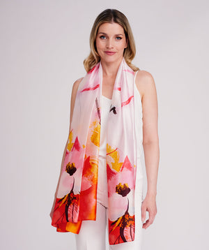 Pink oblong scarf featuring a bold abstract floral print in vibrant pink hues for a statement summer look. Crafted from soft, lightweight chiffon with a silk-feel finish and delicate hemline edging for a polished drape. Oversized design suitable for versatile styling as a scarf, shawl, or wrap.