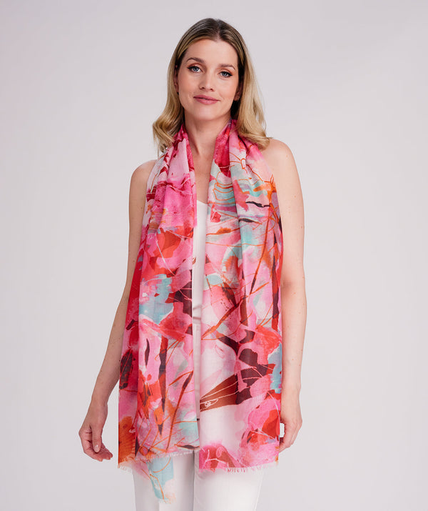 Pink oblong scarf featuring a bold abstract floral print in vibrant pink tones for a fresh seasonal statement look. Crafted from soft, lightweight chiffon with a smooth drape and raw edging for a modern finish. Oversized design suitable for versatile styling as a scarf, shawl, or wrap.
