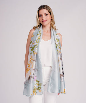 Blue oblong scarf featuring a vibrant abstract floral print in rich blue tones for an elegant statement finish. Crafted from soft, lightweight silk-feel fabric with polished edging for a refined look. Sized 85 x 180 cm for versatile styling as a scarf, wrap, or shawl.
